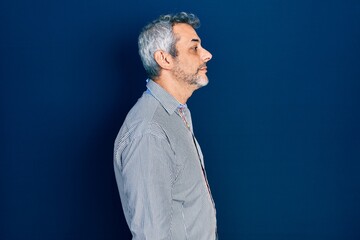 Poster - Handsome middle age man with grey hair wearing business shirt looking to side, relax profile pose with natural face with confident smile.