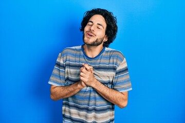 Sticker - Handsome hispanic man wearing casual clothes over pink background begging and praying with hands together with hope expression on face very emotional and worried. begging.