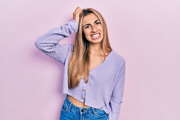 Wall Mural - Beautiful hispanic woman wearing casual shirt confuse and wonder about question. uncertain with doubt, thinking with hand on head. pensive concept.