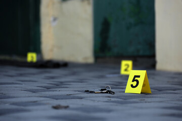 Evidence with yellow CSI marker for evidence numbering on the residental backyard in evening. Crime scene investigation concept