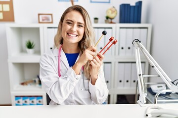 Sticker - Young beautiful doctor woman holding diapason instrument smiling with a happy and cool smile on face. showing teeth.