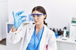 © Krakenimages.com - Young hispanic woman wearing scientist uniform holding pill at laboratory