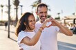 © Krakenimages.com - Middle age man and woman couple doing heart symbol with arms at street