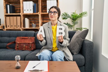 Poster - Young hispanic woman working at consultation office smiling looking to the side and staring away thinking.