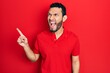 © Krakenimages.com - Hispanic man with beard pointing with fingers to the side angry and mad screaming frustrated and furious, shouting with anger. rage and aggressive concept.