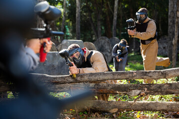 Poster - Portrait of team of adults playing on paintball battlefield outdoor