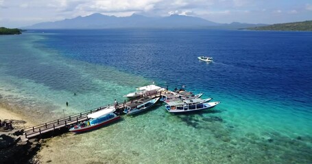 Wall Mural - Menjangan Island, bali, Indonesia. Aerial drone view. Slow turn to show a small pier with diving boats, the coastline of sand and mangroves.