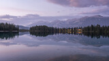 Fototapeta Góry - Colourful sunset on mirrorlike lake with mountains in backdrop, Jasper National Park, Canada