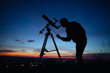Wall Mural - silhouette of a man, telescope and countryside under the starry