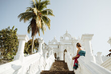 A Girl In A Sari Against The Backdrop Of A White Buddhist Temple In Sri Lanka