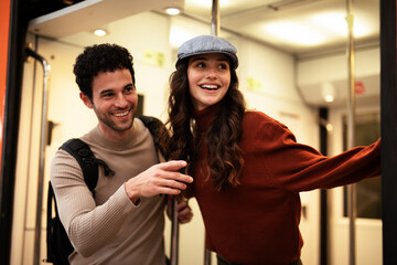 Beautiful couple at railway station waiting for the train. Young woman and man waiting to board a train