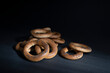 Sushki, bagels, taralli, bakery products with poppy seeds on a dark background