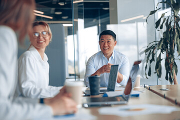 Young Asian businessman listening his colleagues on meeting in modern office. Teamwork concept