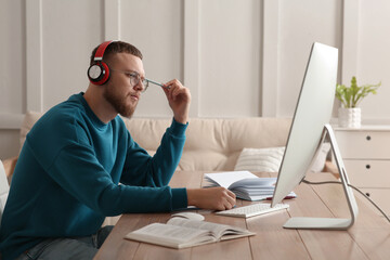 Canvas Print - Online test. Man studying with computer at home