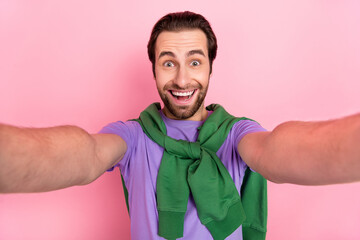 Wall Mural - Photo of optimistic young beard man do selfie wear purple t-shirt isolated on pink color background