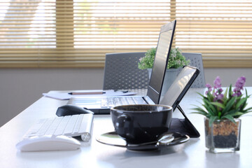Poster - Laptop in office, cafe co-working table with laptop, stationery, and indistinct cafe interior in the backdrop