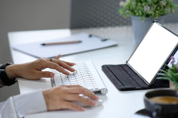 Poster - Close-up of a female specialist's hands working on a laptop computer while sitting at a table in a office. Freelancer Woman Interacting on Social Media