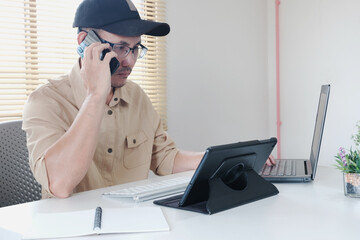 Poster - Businessman using smart phone and laptop at office. Businessman or student working on computer and texting smartphone. Freelance, education and technology concept