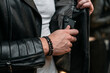 © ChocolateShot - Bracelets made of artificial stones, on a man's hand. Business style, smartphone in pocket.
