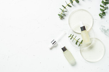 Poster - Essential oil, eucalyptus oil . Glass petri dish with essential oil at white background. Top view with copy space.