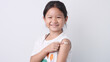 © iHumnoi - Vaccine concept. Happy Asian little child girl smiling, showing arm with plaster bandage after received, getting COVID-19 vaccine injection. Concept of inoculation, vaccinate, campaign, COVID19, Flu