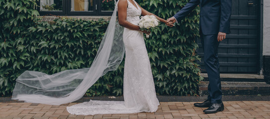 Afro-american bride and caucasian groom posing on a wedding photo shoot