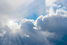 Rays Of Sunlight In Blue Cumulus Clouds, Background.