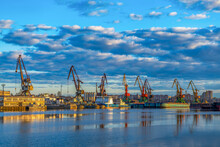Ships, Barges In Soft Focus In The Cargo Port Against The Background Of Sunset, Dawn, In The Rays Of The Sun In Cherepovets, Russia. Industrial Urban Landscape, Transport Logistics.
