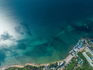 flying over group of the large green island and little city in the never ending blue ocean with cloudy and clear sky weather