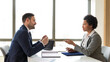 © Route77 - Experienced businessman listen to candidate answers. Young african american women applied for new job position. Concept of stressful job interview,