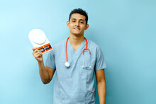 Young Adult Hispanic Doctor Holding A A Scale To Measure Food, Nutritionist Concept.