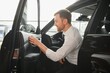 © Serhii - man in a car dealership buys a car