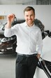 © Serhii - Man buying a car at a showroom