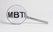 MBTI acronym through magnifying glass. Psychology typology test. High quality photo