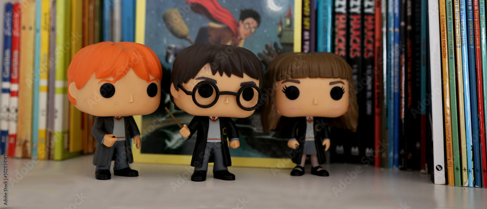 Harry Potter, Hermione Granger and Ron Weasley Funko pop. Toys for kids.  Characters of the movie. hogwarts. Students of magic and sorcery.  Background books. Library. Stock Photo | Adobe Stock