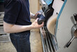 © Olga - the master repair shoes at the machine, in the workshop. Shoemaker's workplace, manual labor, shortage of jobs