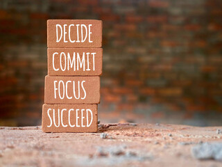 Wall Mural - Inspirational and Motivational Concept - DECIDE COMMIT FOCUS SUCCEED text on bricks background. Stock photo.