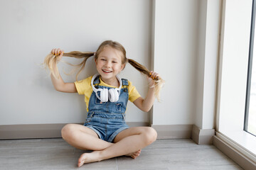 cute little girl at home with headphones