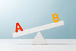 letter a and b on the unbalanced seesaw. evaluation concept.