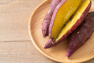 Wall Mural - Grilled or baked Japanese sweet potatoes on wood plate