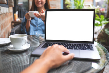 Mockup image of a man using and touching on laptop touchpad with blank white desktop screen with a woman in cafe