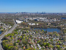 Arlington Heights Suburban Landscape Aerial View In Spring With Little Pond And Boston Modern City Skyline At The Background In Historic Town Of Arlington, Massachusetts MA, USA. 