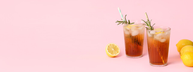 Wall Mural - Glasses of tasty iced black tea with lemon on pink background with space for text