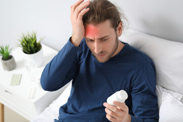 Poster - Young man with pills against headache in bedroom