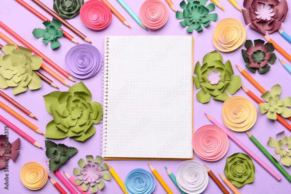 Composition with blank notebook, paper flowers and colorful pencils on color background