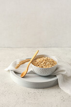 Bowl Of Raw Oatmeal And Spoon On Light Background