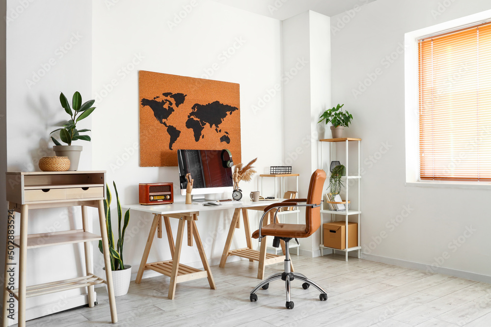 Workplace with modern computer near white wall in room interior
