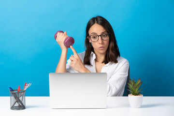 Wall Mural - Hispanic fitness coach on video conference in front of laptop isolated on blue background.