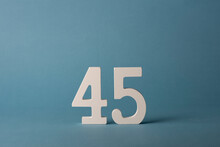 White Wooden Number Forty-five 45 On Blue Background.