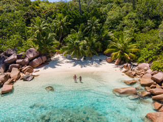 Wall Mural - Praslin Seychelles tropical island with withe beaches and palm trees, couple of men and women mid age on vacation at Seychelles visiting the tropical beach Anse Lazio Praslin Seychelles. drone view 